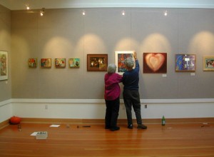 Here volunteers, Judy Sorrel and Vivi Tallman, are hanging the first show - Art About Community - at the North County Recreation District Gallery in November, 2005.